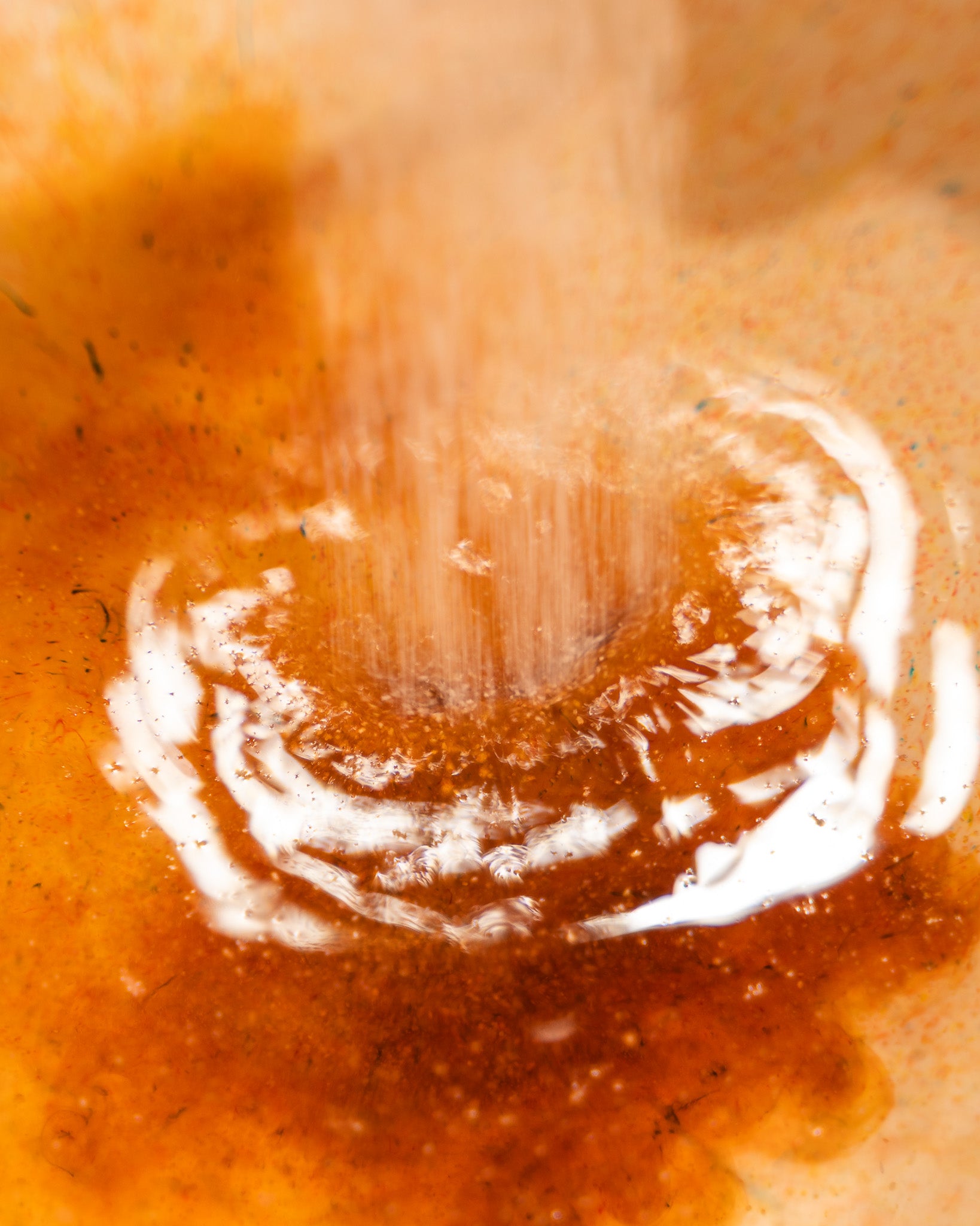 Close-up of a water droplet on a textured orange surface