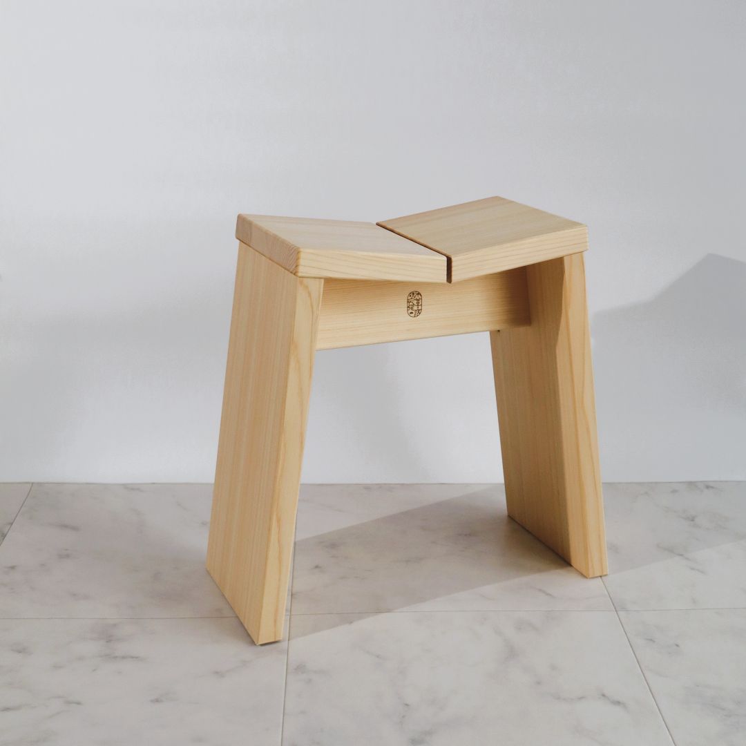 Wooden stool on a light-colored floor with a plain background