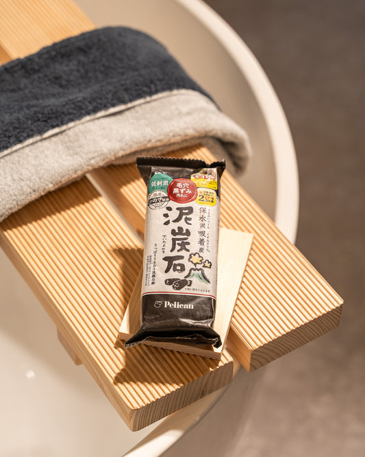 Bar of soap with packaging on a wooden soap dish