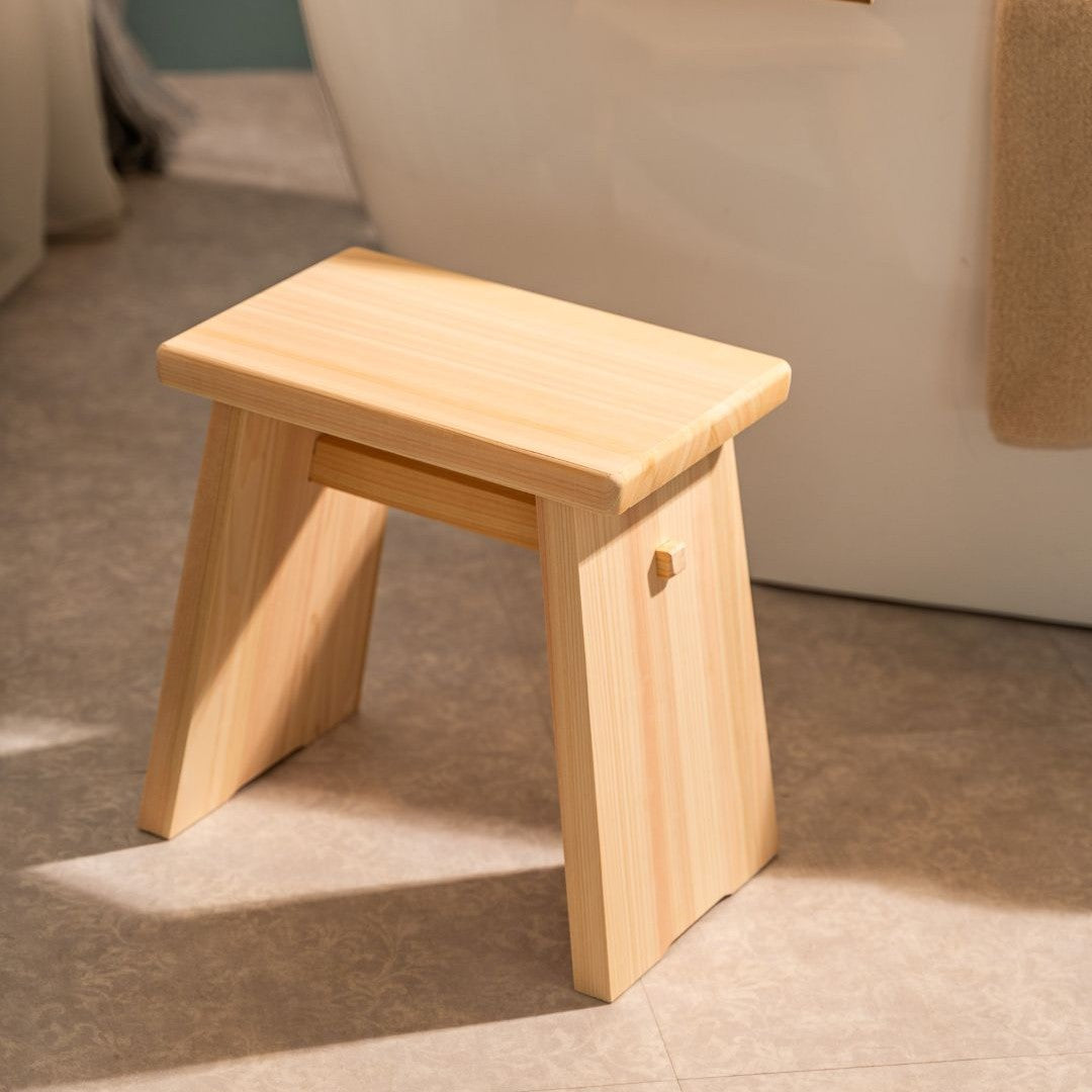 Wooden stool on a tiled floor with a neutral background