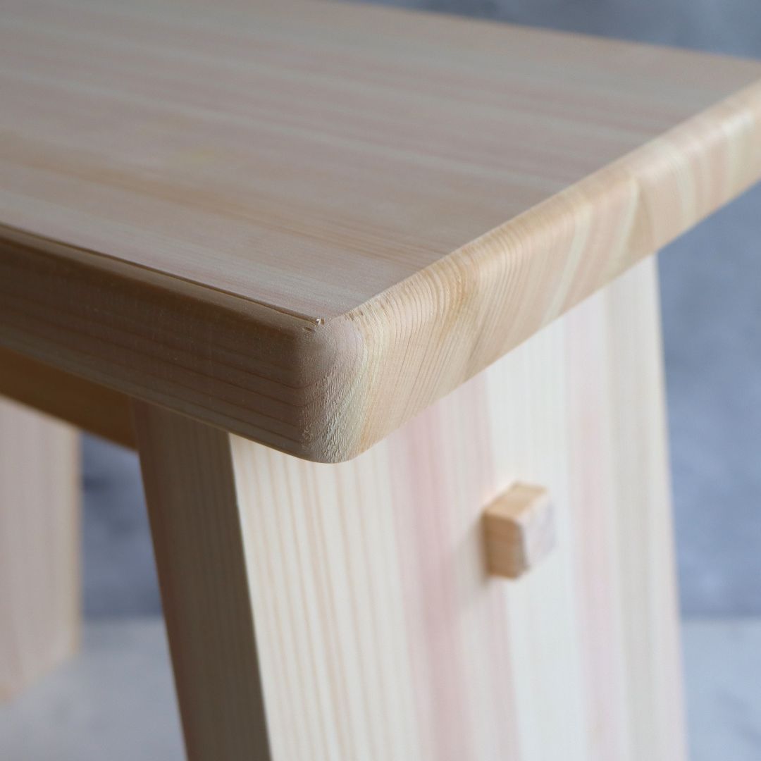 Close-up of a wooden bathroom stool with a blurred background