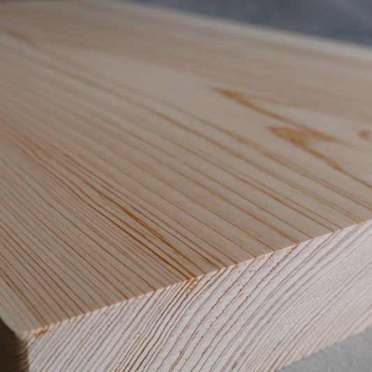 A close-up view of the fine wood grain on a premium cutting board made from a single slab of Shimanto Hinoki wood.