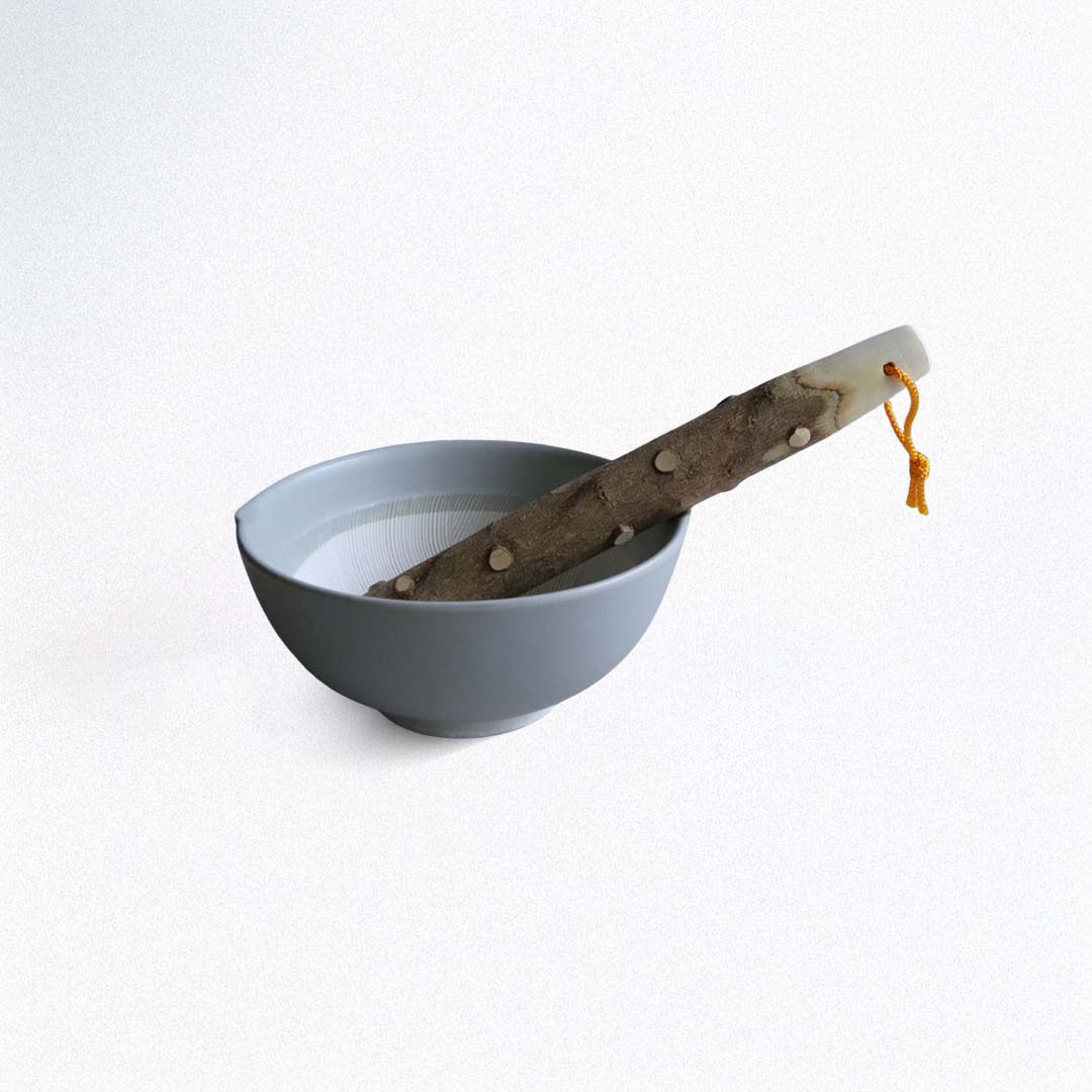 Gray bowl with a wooden pestle stick on a white background