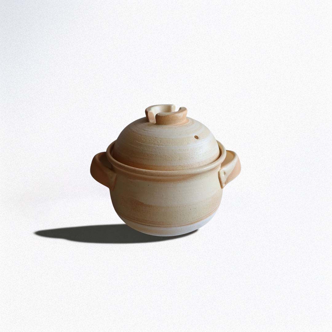 A beige and yellow Yamabuki-glazed ceramic donabe rice cooker with a lid