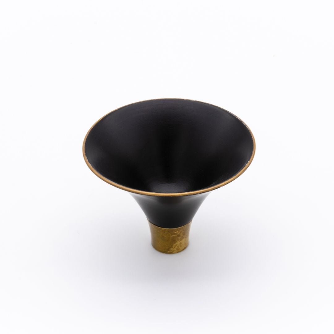 Black and gold decorative object on a white background