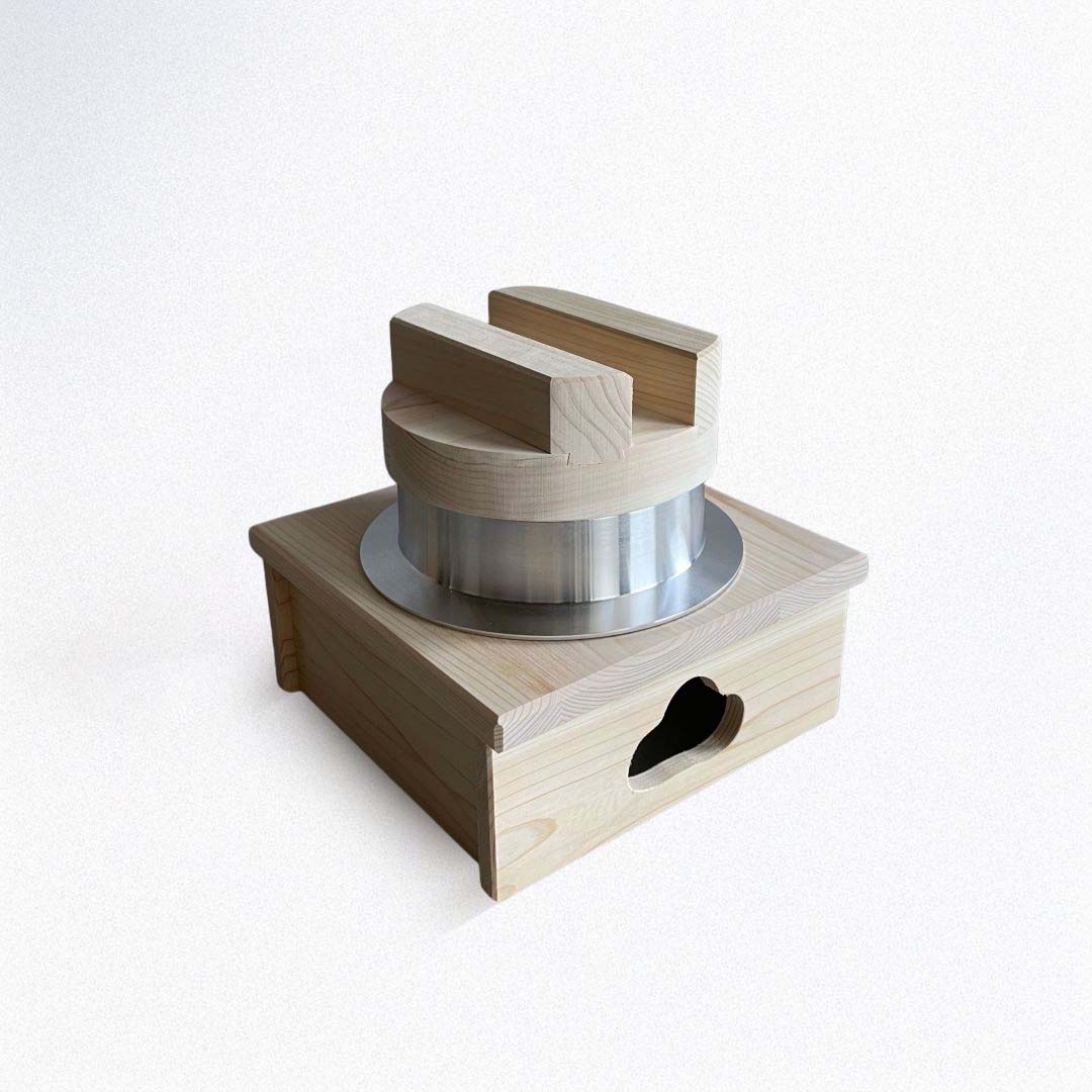 Wooden and metal cylindrical hagama rice pot on a white background
