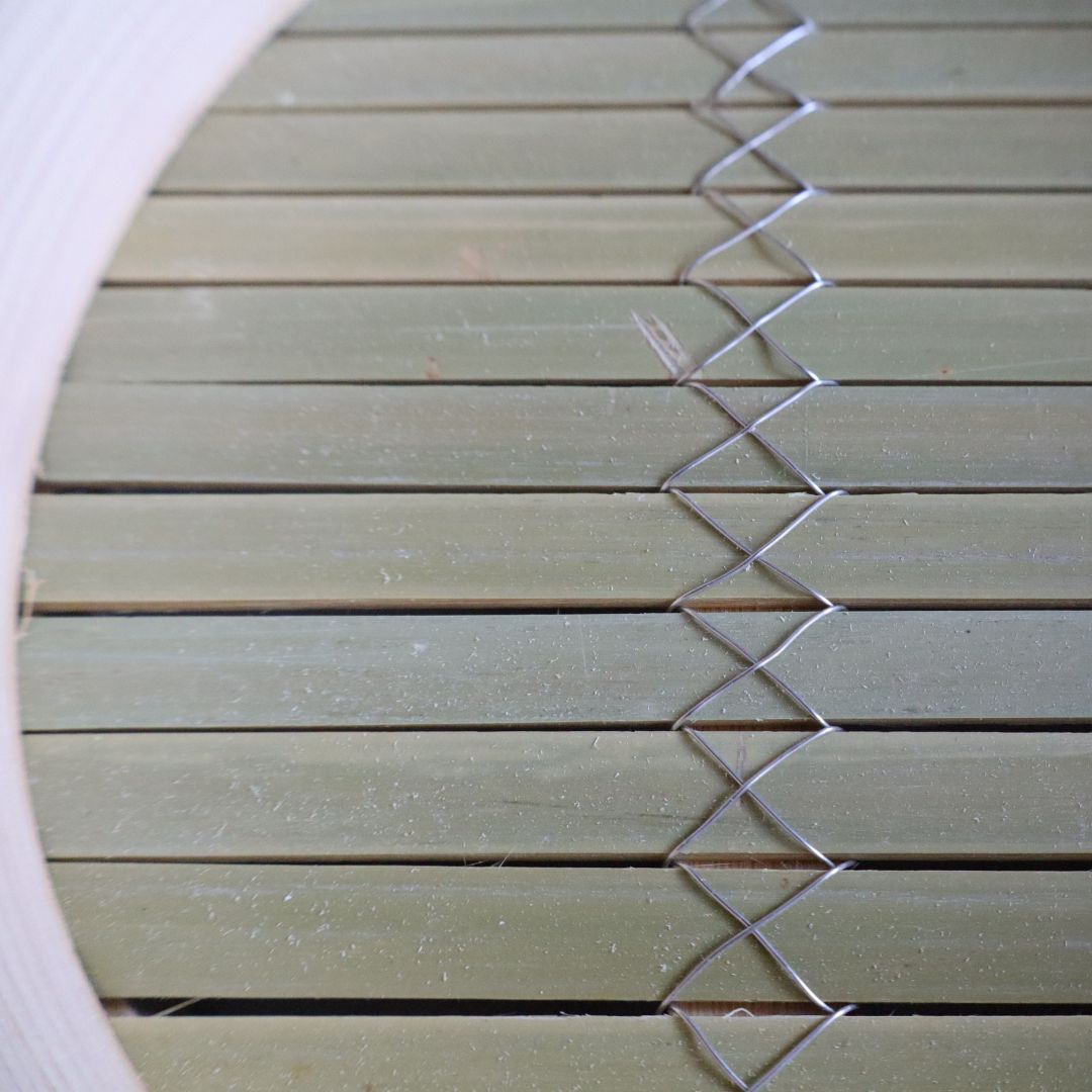 Close-up of a woven mat with a geometric pattern on a white background