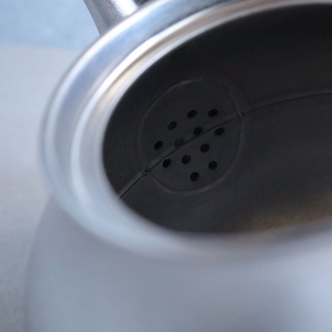 Close-up of a metallic object with a central circular feature on a blurred background