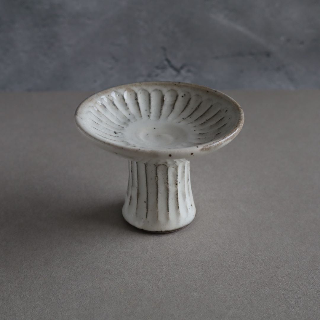 a ceramic saucer plate in a grey room