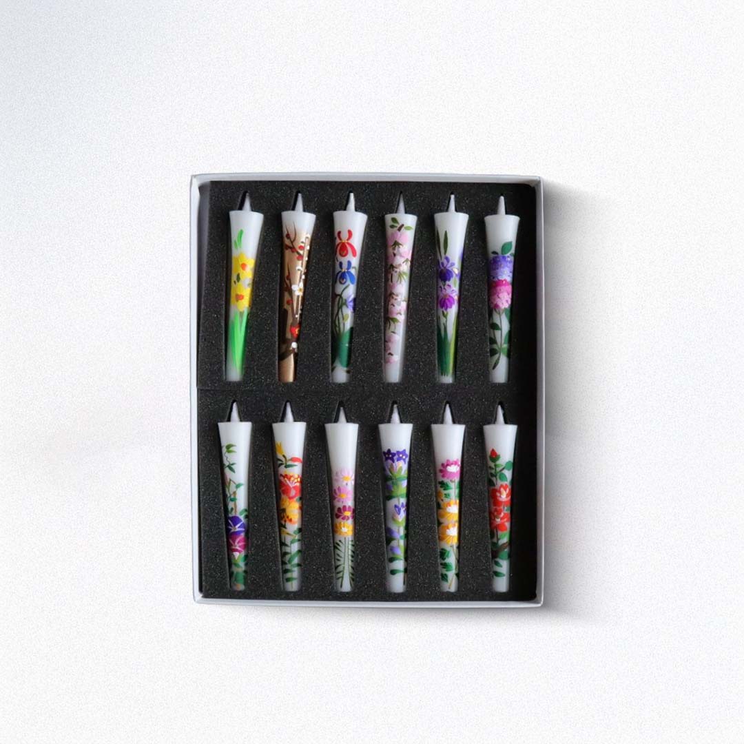 Set of decorated candles in a black box on a white background