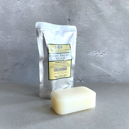 A packaged bar of soap labeled 'Sakura Leaf Handmade Soap' next to an unsliced bar of soap, presented on a grey background.