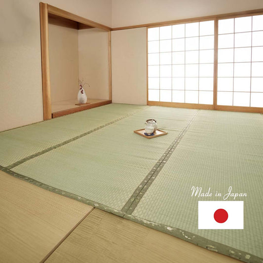 A green tatami mat made of natural rush grass covering the entire floor of a living room. A tea cup is placed in the middle of the tatami mat. A closet is seen at the bottom of the room, while a Japanese screen door is visible on the left side.