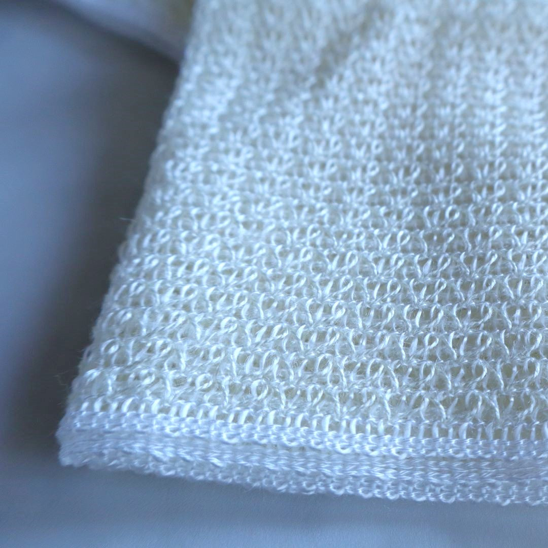 Close-up of a Japanese exfoliating body wash towel in white, featuring a textured, breathable weave for gentle cleansing and a refreshing spa-like bathing experience.