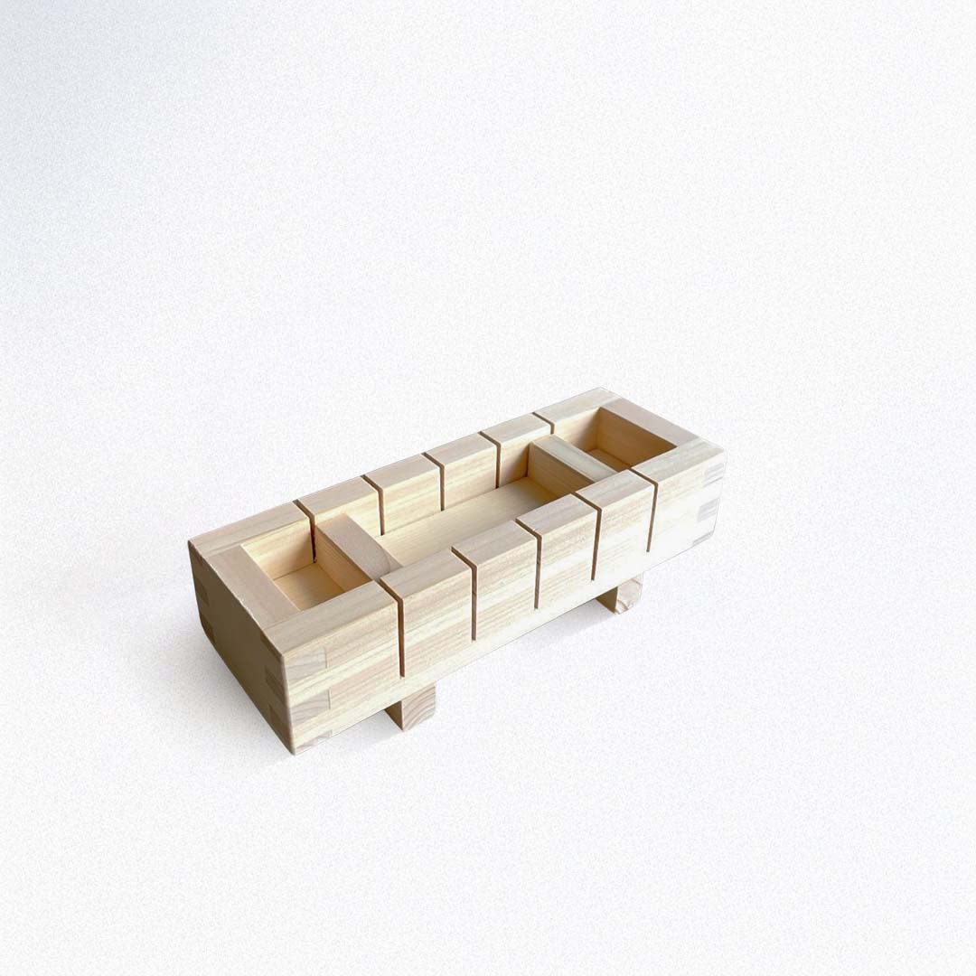 A rectangluar wooden sushi mold to make square sushi on a white background