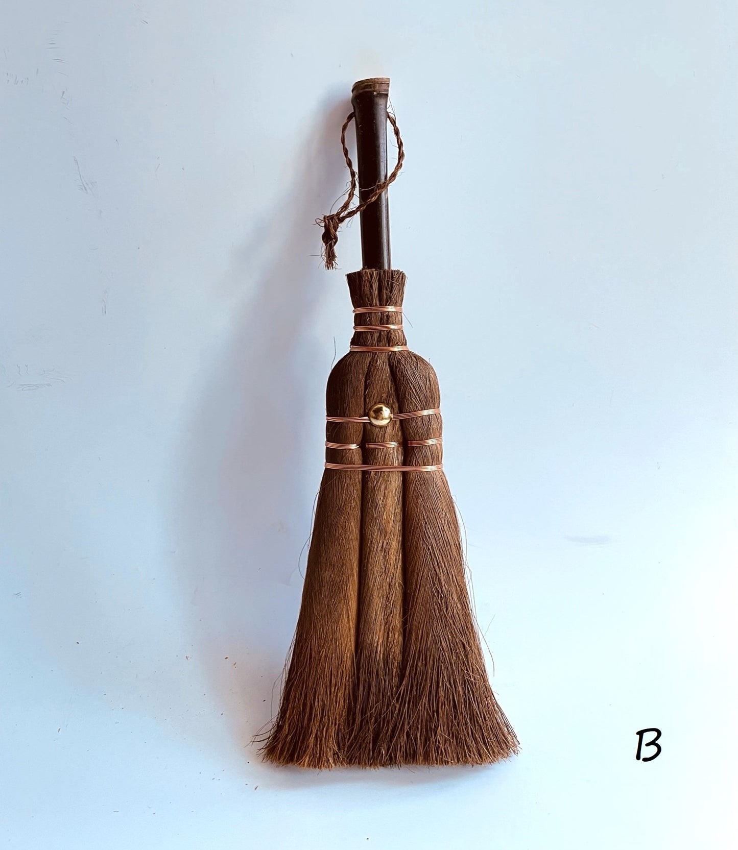 a whisk broom on a grey surface