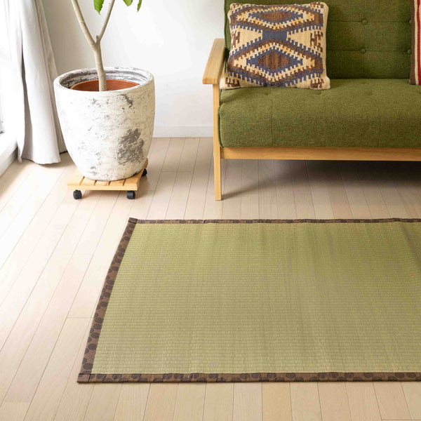 In a living room, a part of a tatami on a floor next to a sofa.