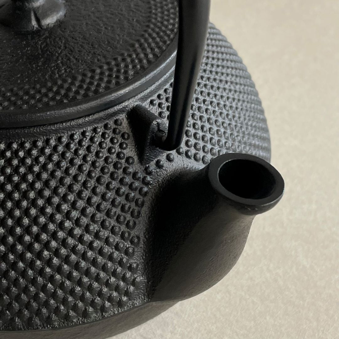 A Japanese teapot hang from a wooden fish in a tatami room