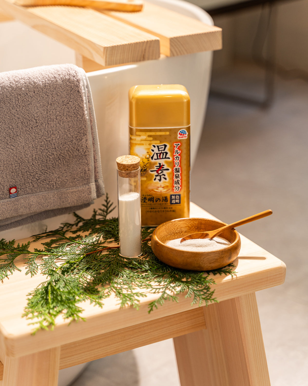 Bottle of Japanese drink with a wooden bowl and towel on a wooden stool