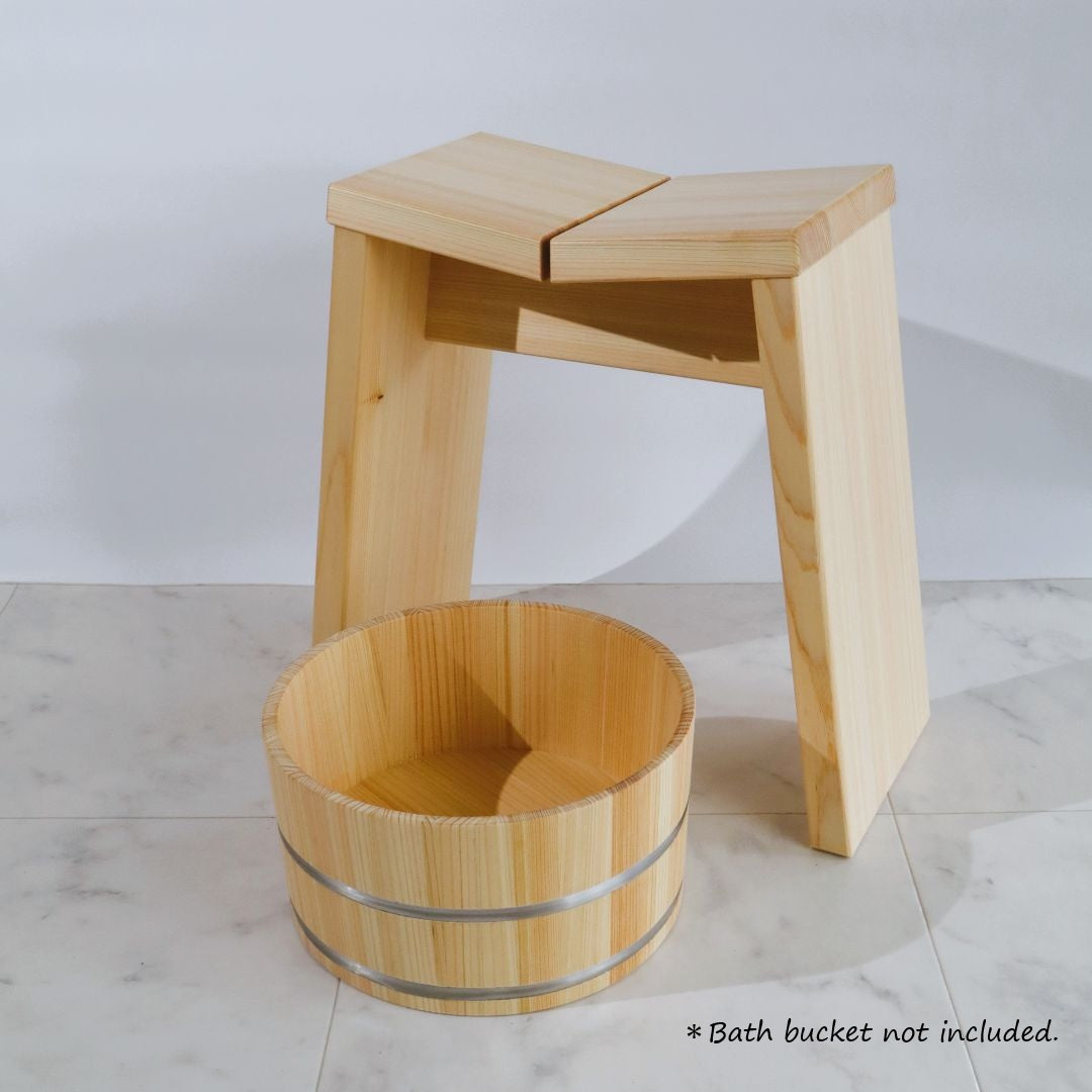 Wooden stool and bucket on a marble floor with a plain background