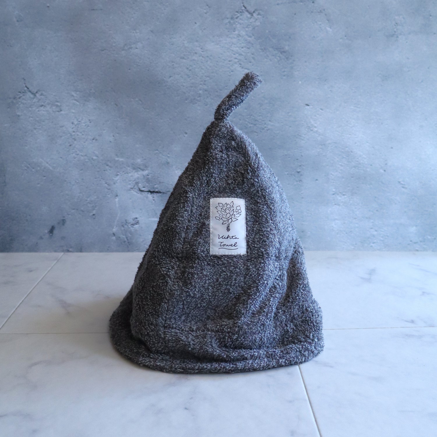 Charcoal-gray sauna hat with loop for hanging in bathhouses; foldable brim for adjustable coverage.