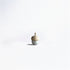 A small acorn-shaped healing bell with a silver base and a wooden top, placed on a smooth surface against a soft, neutral background.