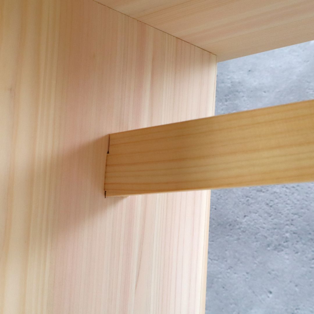Close-up of a wooden bathroom stool joint with a neutral background