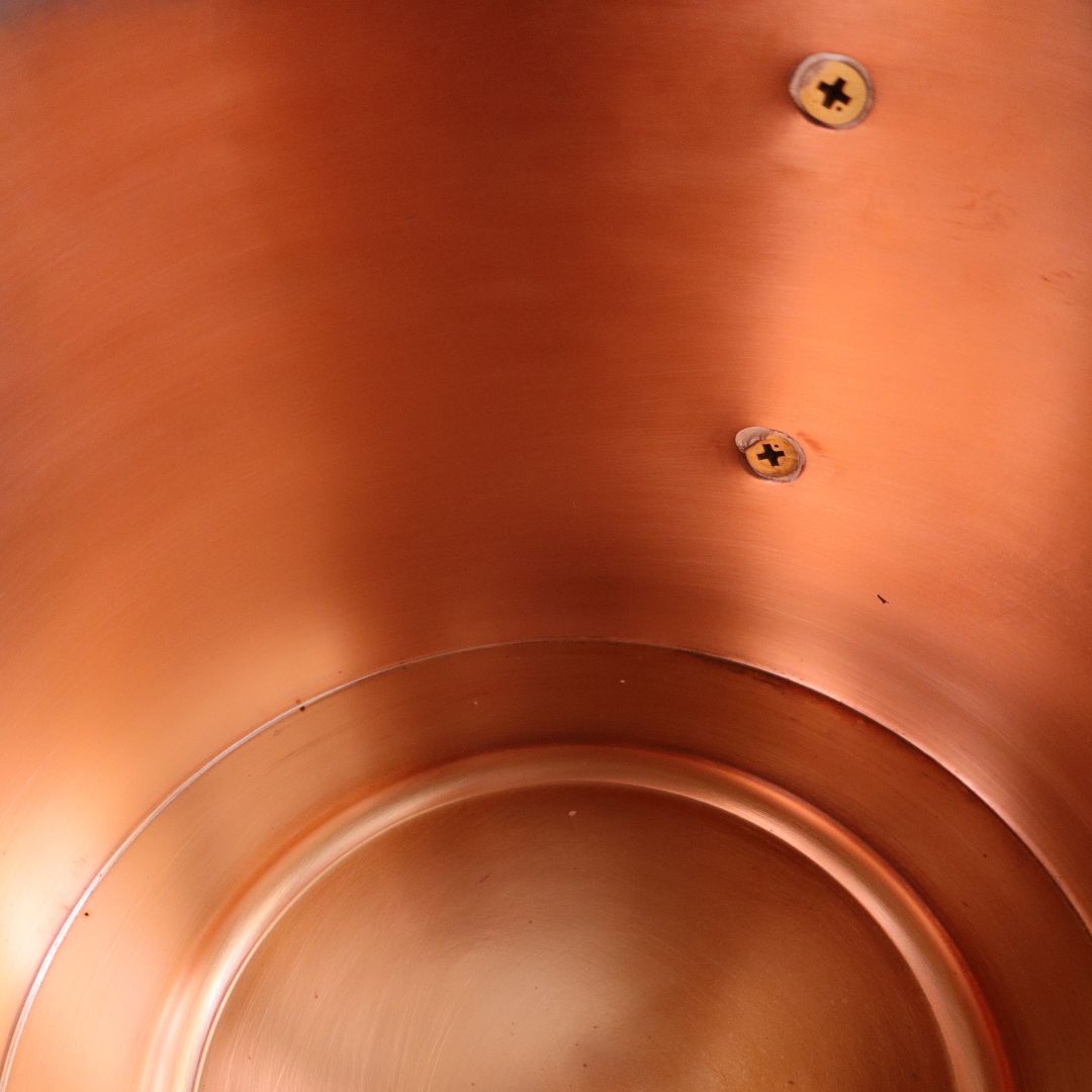 Close-up interior view of a Japanese handmade copper sauna bucket, showing the smooth brushed copper surface and interior screws.


