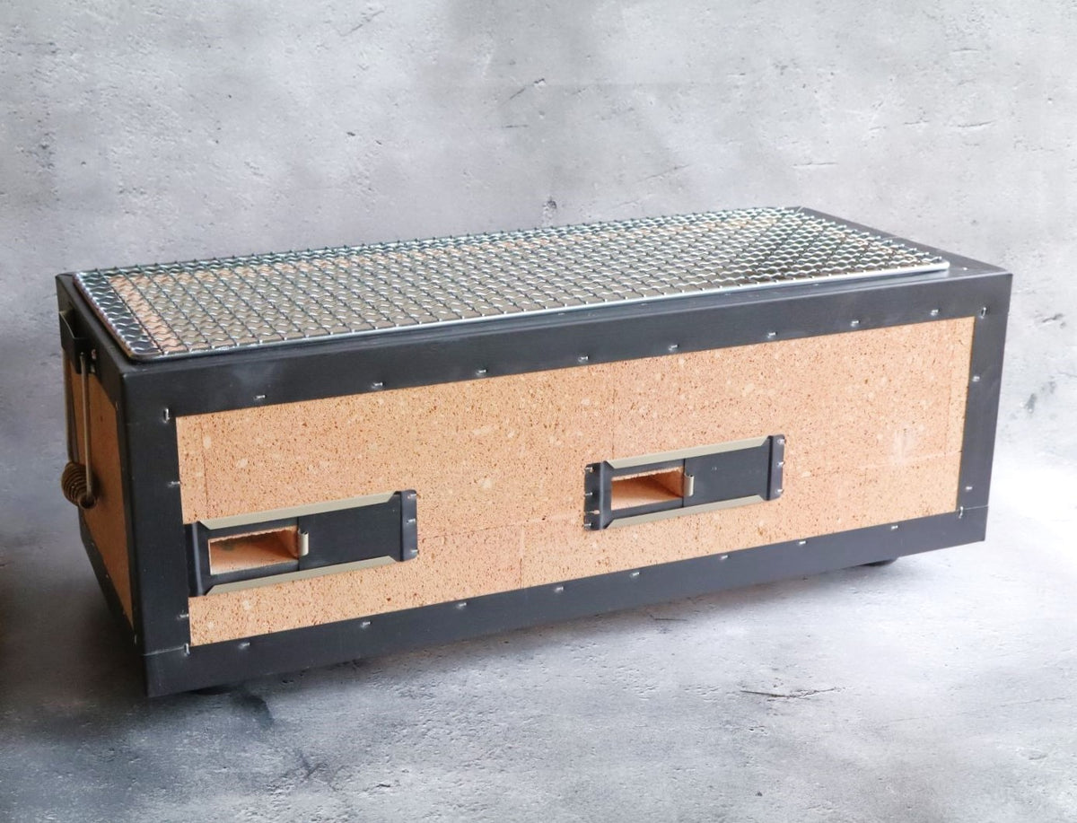 A side view of a Japanese rectangular hibachi grill featuring cork insulation and metal framing with a wire grilling surface.