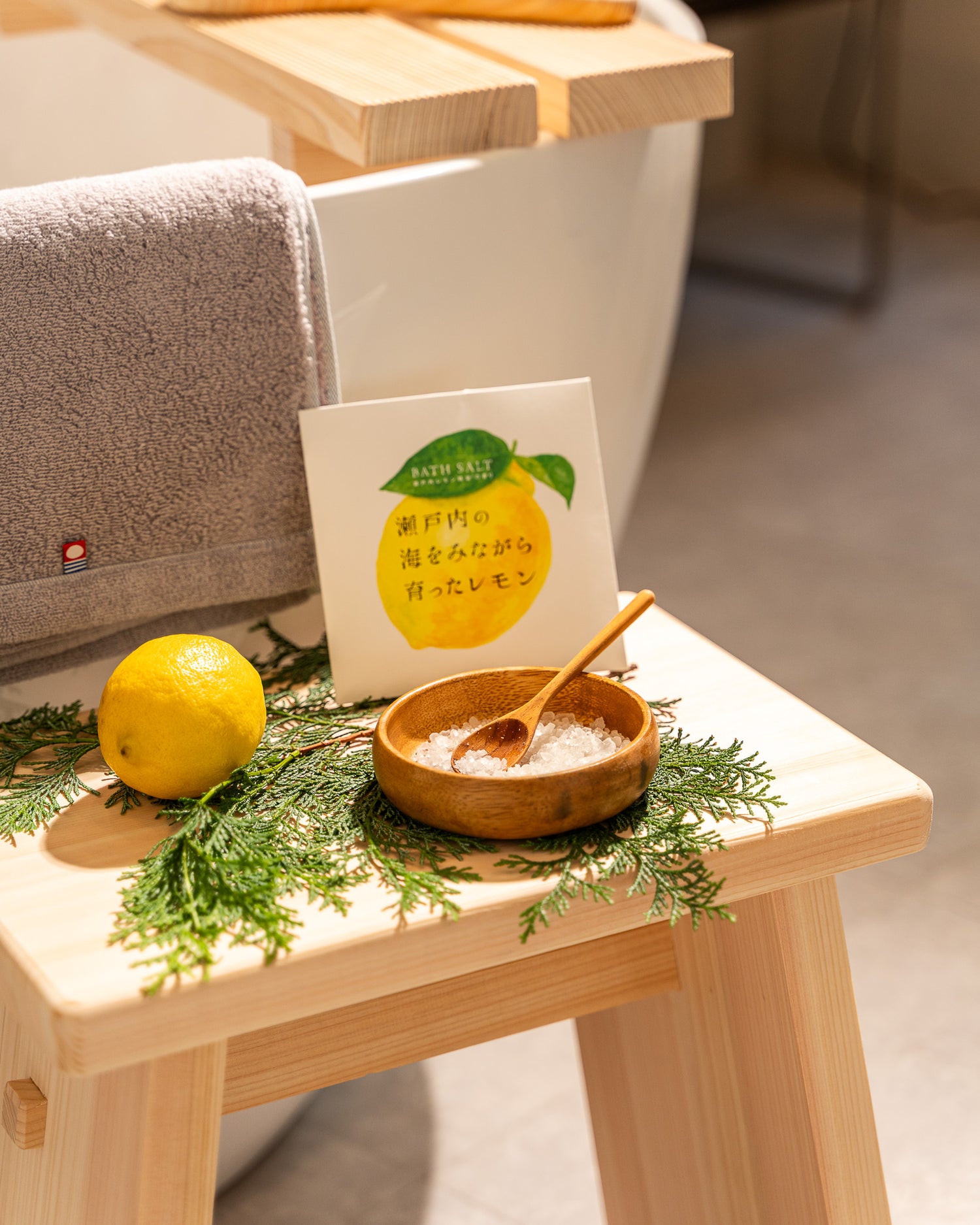 Small wooden table with a lemon, a bowl of sugar, and a card on a light background
