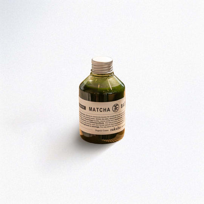 Bottle of matcha green tea bath essence on a white background
