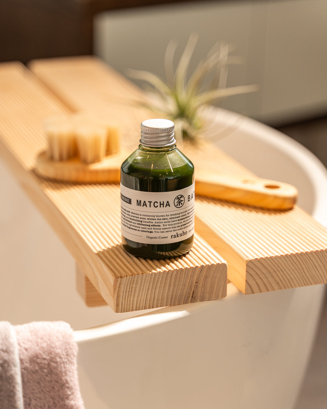 Matcha bottle on a wooden tray over a bathtub