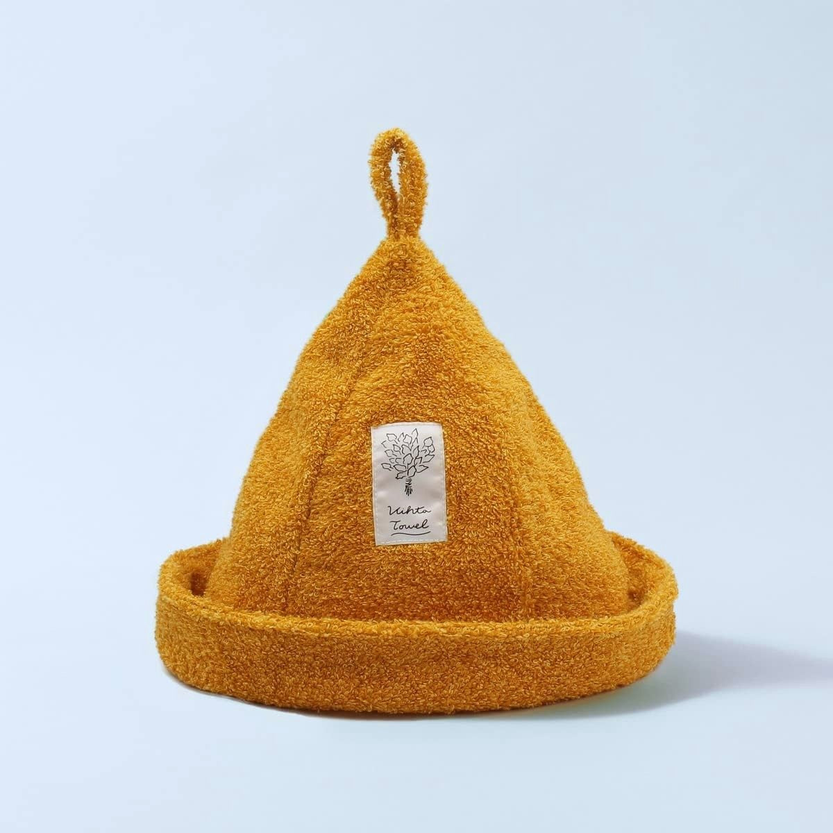 Yellow textured beanie with a label on a light blue background