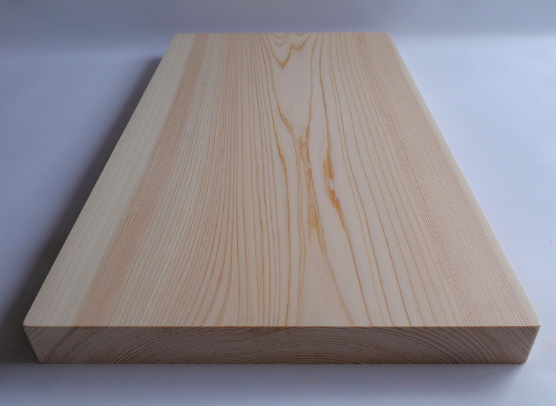 A detailed look at the smooth texture and natural lines of a Shimanto Hinoki cutting board, made from a single piece of wood.