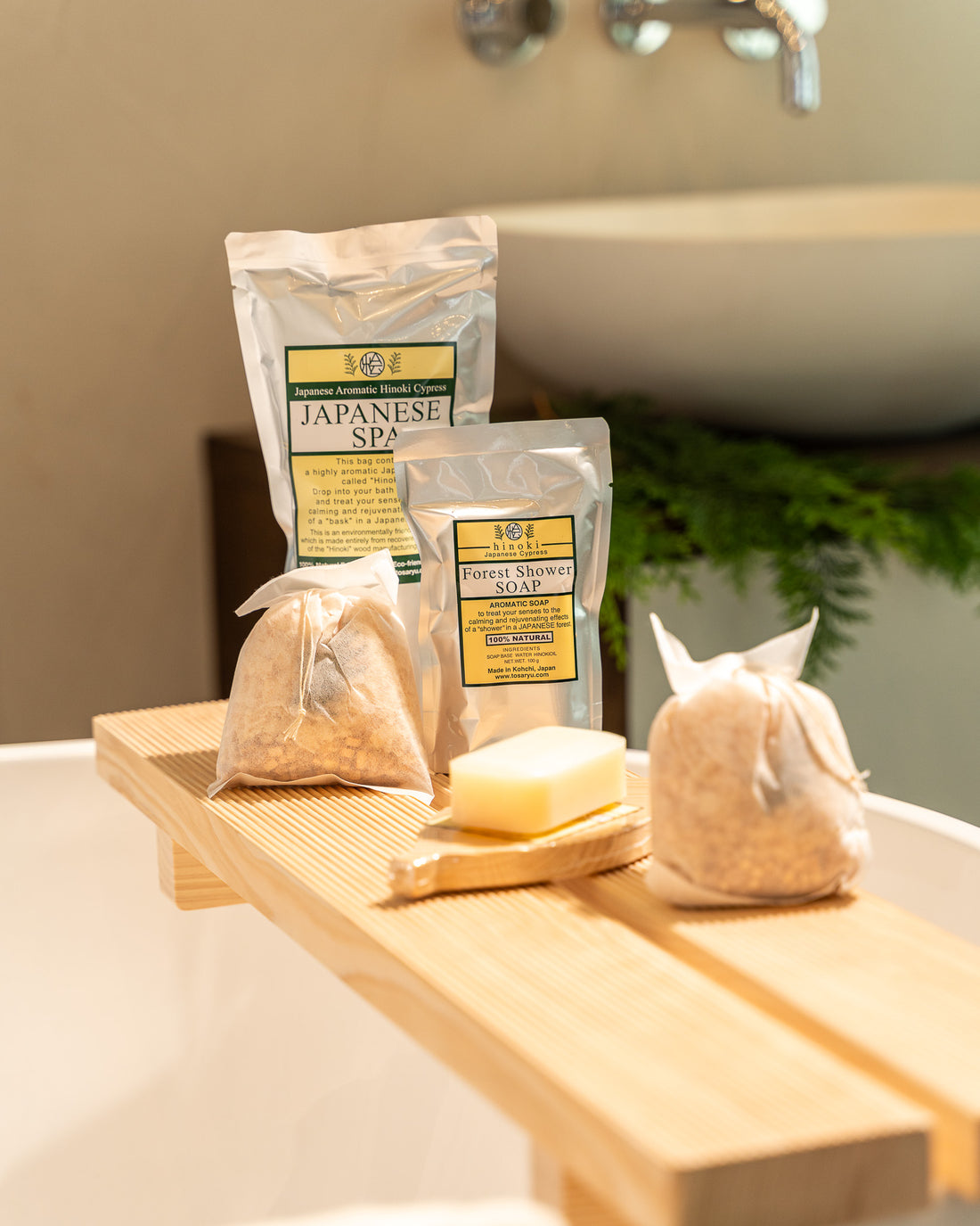 Bath products including soap and loofah on a wooden tray with a bathtub in the background.
