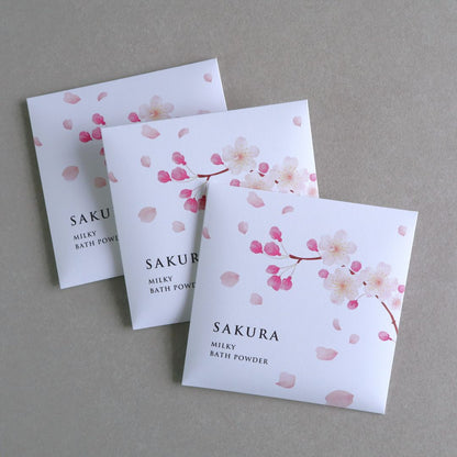 Three packs of Sakura Milky Bath Powder with a cherry blossom design on the packaging.