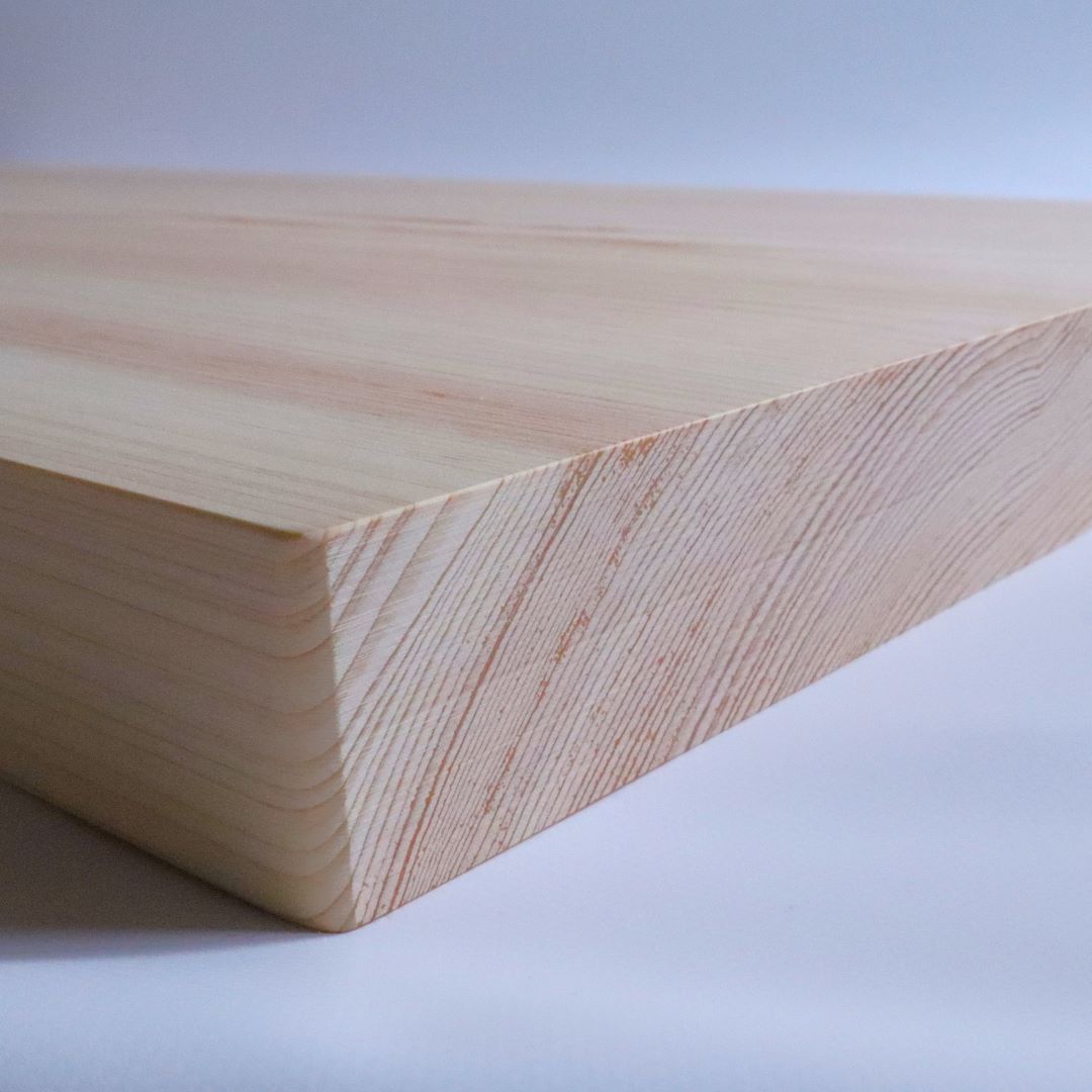 A close-up of the edge of a Shimanto Hinoki cutting board, showing the precise craftsmanship and natural beauty of the wood grain.