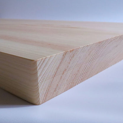 A close-up of the edge of a Shimanto Hinoki cutting board, showing the precise craftsmanship and natural beauty of the wood grain.