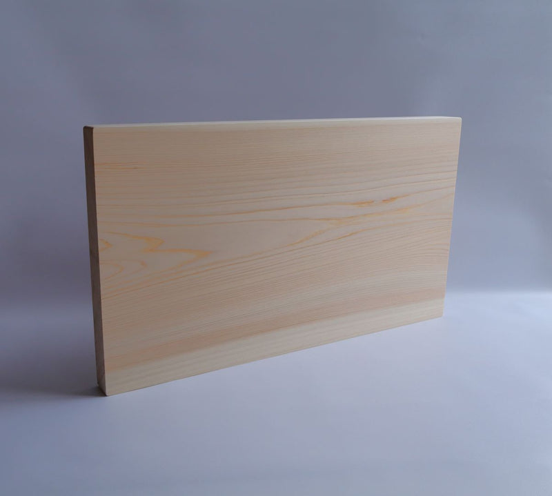 A side angle of a thick cutting board crafted from a single slab of Shimanto Hinoki, highlighting the clean edges and sturdy build.