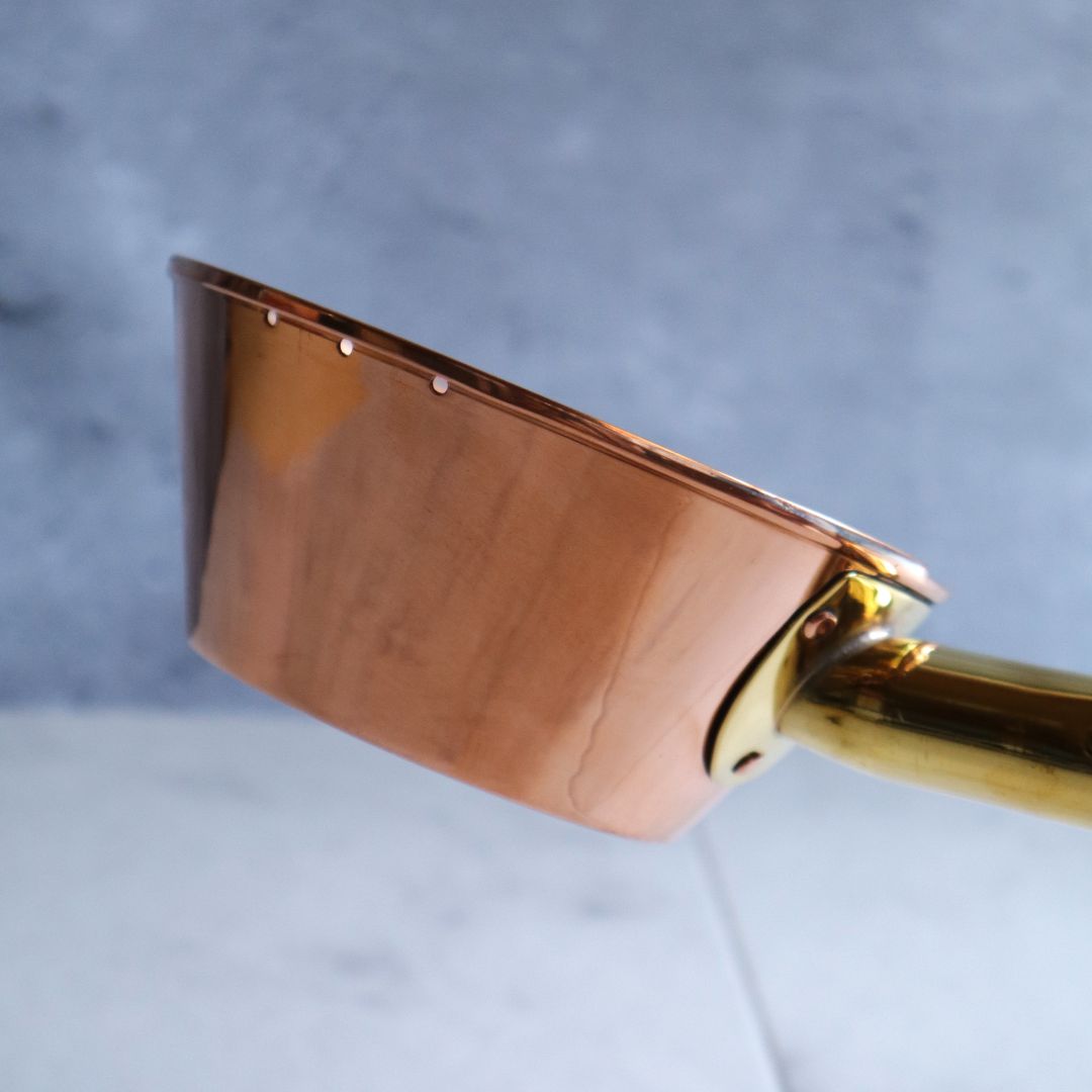 Elegant side view of a copper sauna ladle, handcrafted by skilled artisans in Tsubame, Niigata, using the traditional hera-shibori technique.