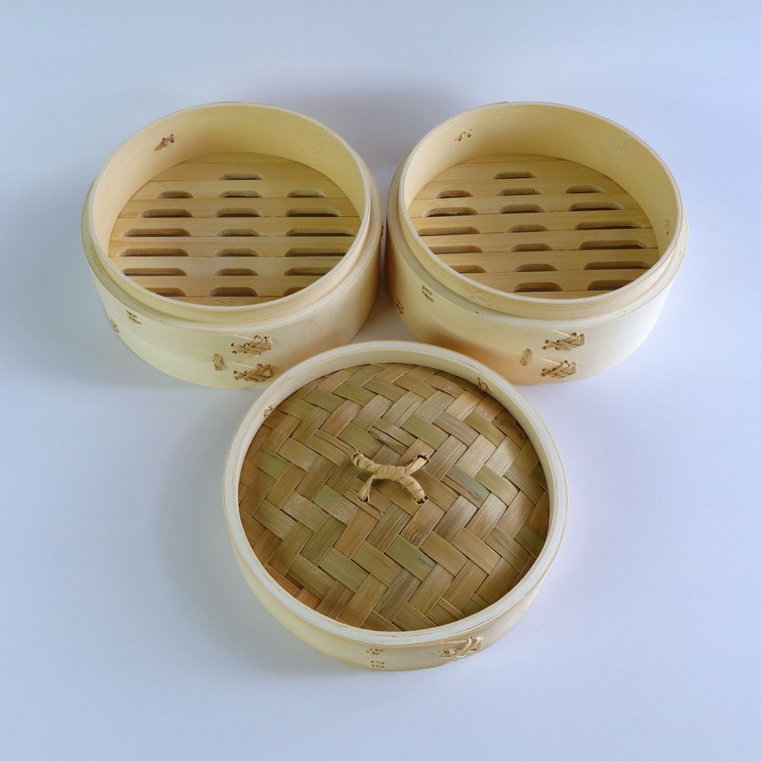 Two-tier bamboo seiro steam basket with the lid removed, revealing the bamboo slatted bottoms. The set includes a woven bamboo lid.