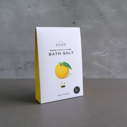 Side view of the Yuzu Bath Salt packaging, showing the minimalist design with a yellow accent on the side.