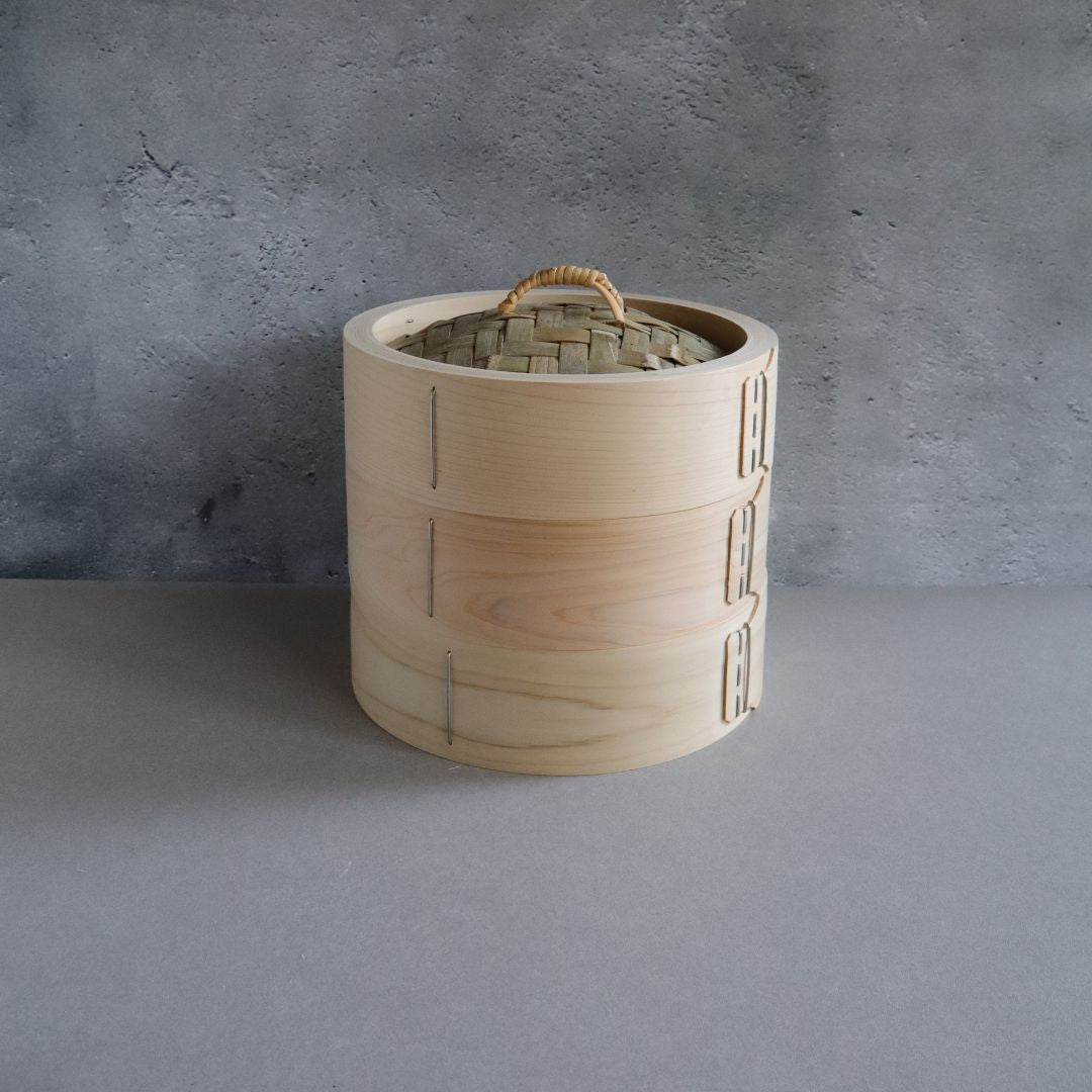 Wooden basket with a woven lid on a gray background