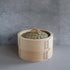 bamboo steaming basket standing in a a grey room