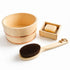 A natural bamboo bath set on a white background, including a wooden bath bowl with copper bands, a wooden soap dish holding a bar of soap, and a wooden-handled brush with dark bristles.