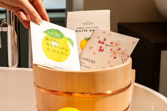 Bath salt packaging with Yuzu and Sakura scents in a wooden container.