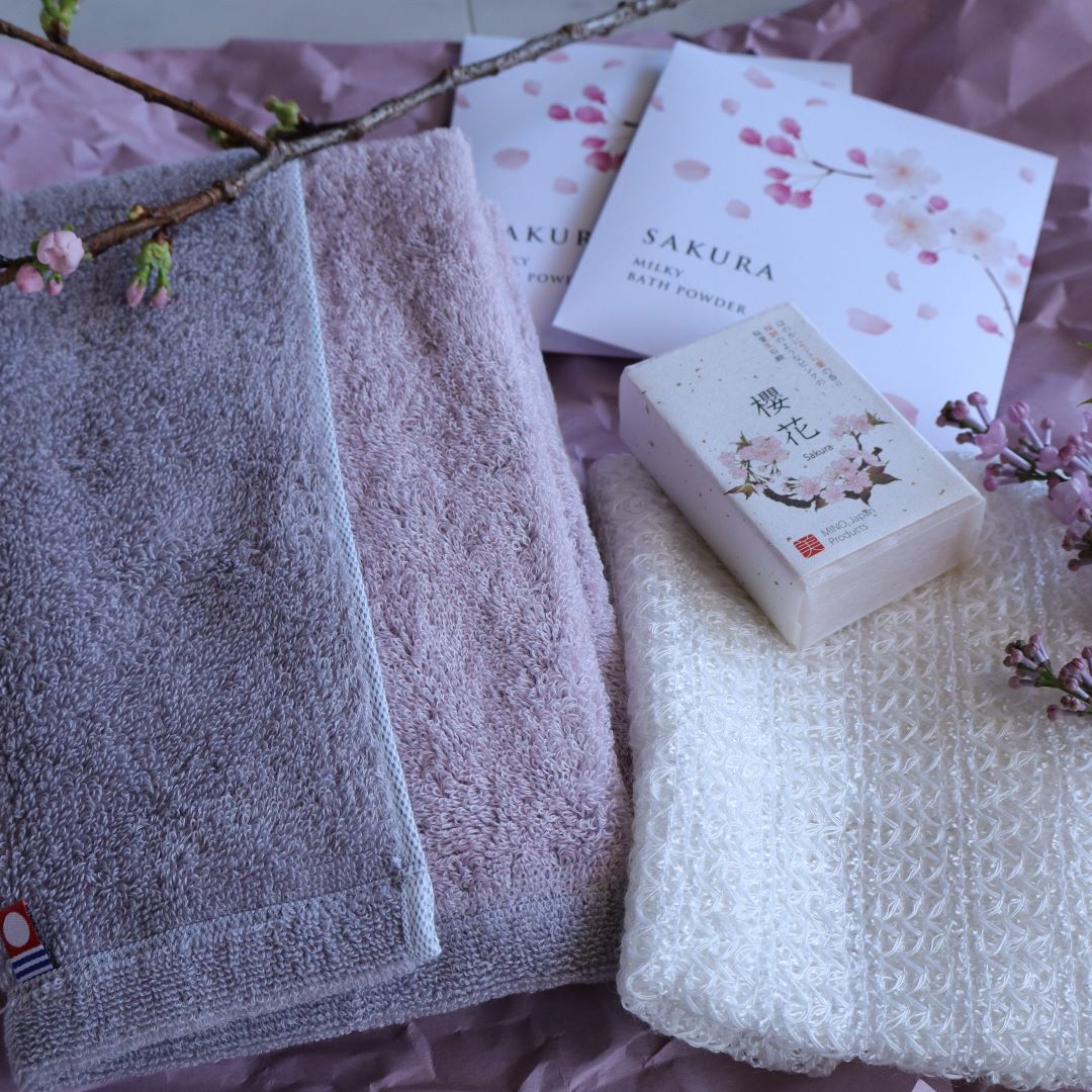 two towel, a soap and sakura milk bath salt