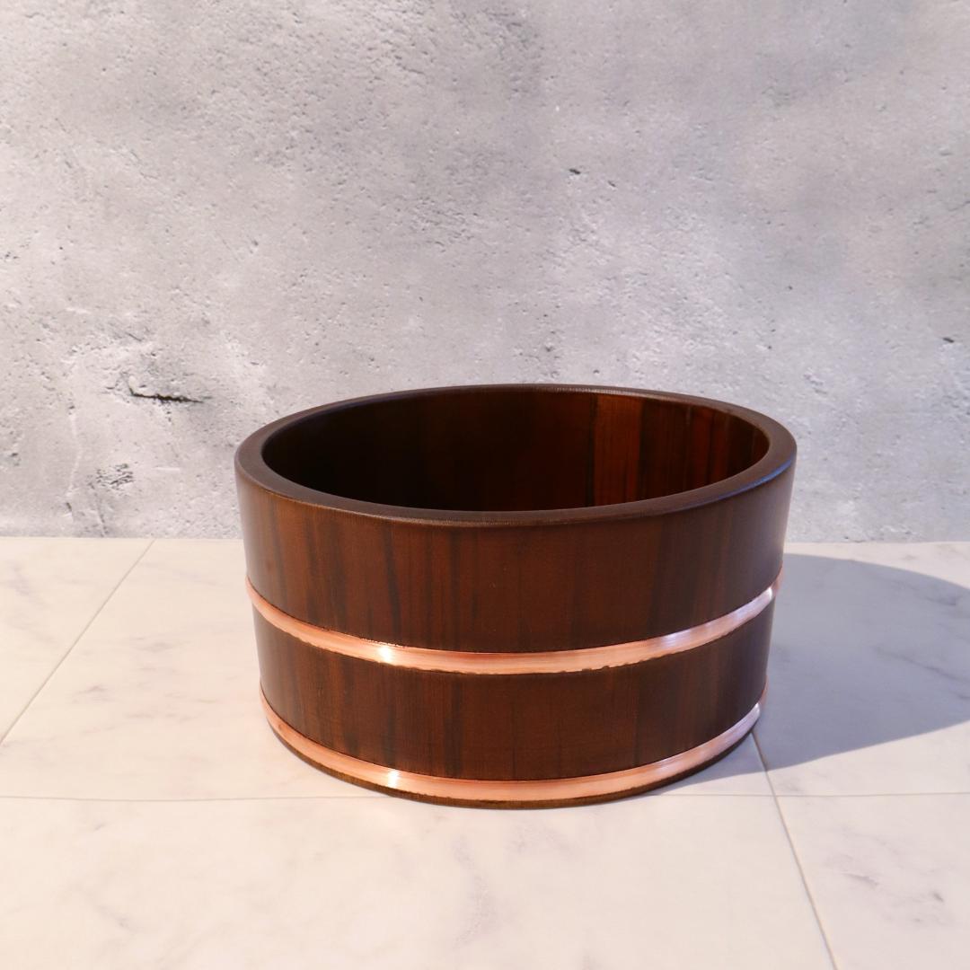 Wooden barrel with copper band on a concrete floor