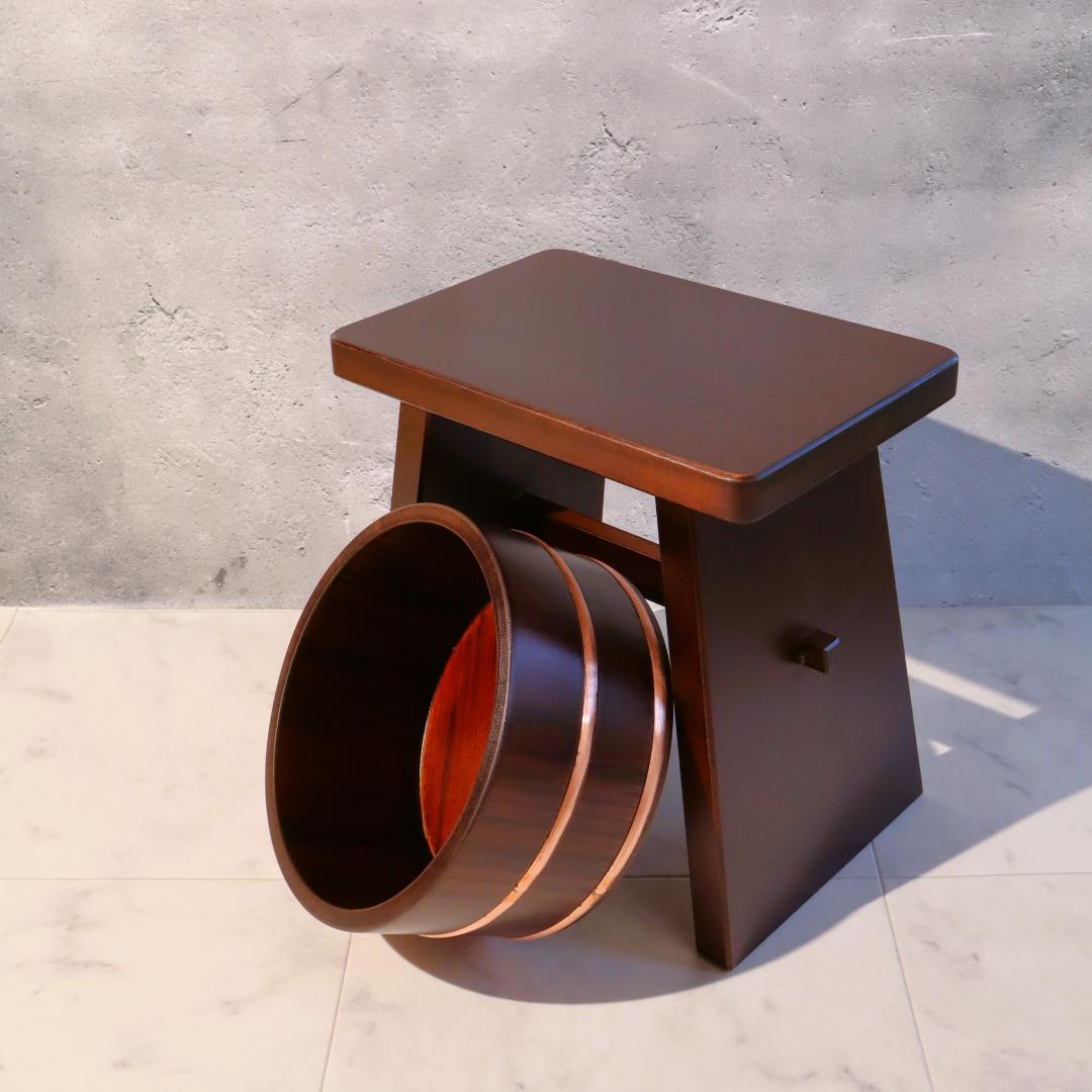 Wooden stool with a unique design on a concrete floor.
