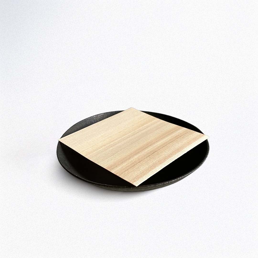 Round black plate with a wooden paper center on a white background
