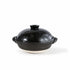 A black ceramic lidded pot with side handles and a textured glaze, set against a plain white background.